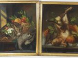 deux tableaux représentant un chat et une corbeille de fruits posés sur une table