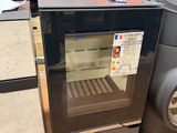 a small oven sitting on the floor next to other appliances