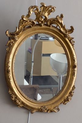 un miroir accroché au mur à côté d'une lampe