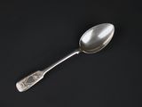 a close up of a silver spoon on a black surface