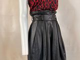 a mannequin wearing a red and black top and black leather skirt