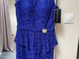 a blue dress hanging on a hanger in a room