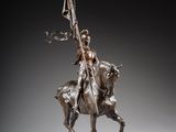 bronze statue of a man on a horse holding a flag