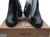 black leather ankle boots with a bow tie on top of a cardboard box