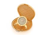 an image of a gold watch in a woven case on a white background