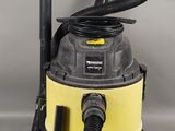 un gros plan d'un aspirateur à eau jaune et noir posé sur une surface grise