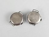 pair of silver plated pocket watches on a white surface