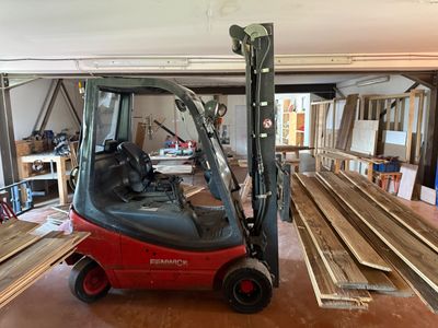 un chariot élévateur dans un entrepôt où le sol est recouvert de planches de bois
