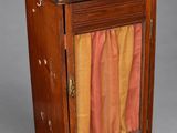 une vieille armoire en bois surmontée d'un rideau coloré