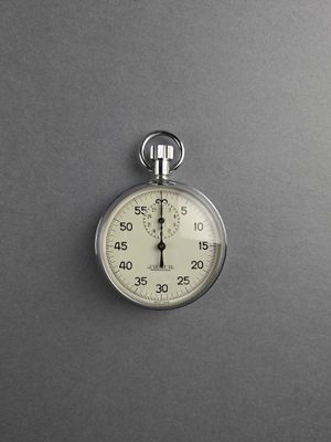 a stopwatch on a gray surface with a black background