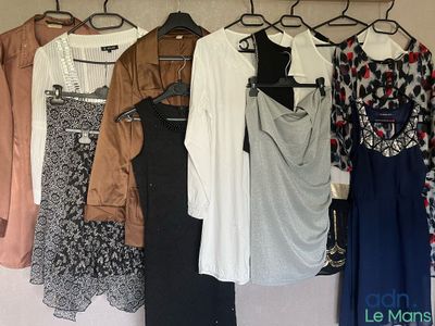 beaucoup de vêtements suspendus à une étagère dans une pièce