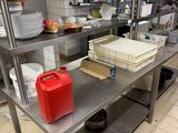 a red canister sitting on a metal table in a kitchen
