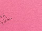 a close up of a piece of pink paper with writing on it