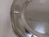 une assiette en argent posée sur une table recouverte d'une nappe blanche