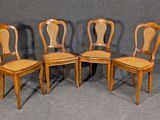 quatre chaises en bois avec un dossier en rotin, sur fond gris