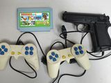 deux manettes de jeu vidéo et un pistolet posés sur une table