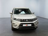 the front view of a white suzuki suv parked in a white room