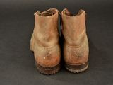 an old pair of brown boots sitting on top of a black surface