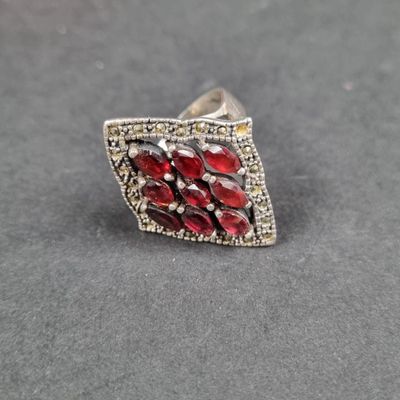un gros plan d'une bague en argent sertie de pierres rouges