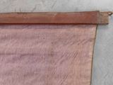 an old pink cloth hanging on a wall next to a pair of scissors