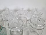 many glass containers with lids on a table