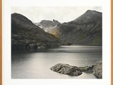 a black and white photo of a lake with mountains in the background