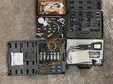 de nombreux outils différents rangés dans une mallette posée par terre