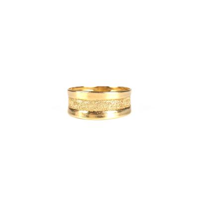 gros plan d'une bague en or sur fond blanc