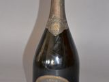 an old bottle of champagne sitting on top of a white table