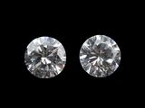 two round brilliant cut diamonds on a black background