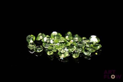 un tas de diamants verts sur une surface noire