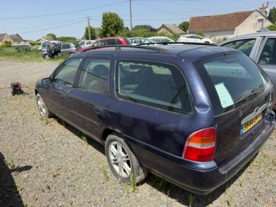 a blue car parked in a lot with other cars in the background