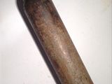 a small metal bottle with a wooden handle sitting on a table