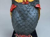 une statue représentant un hibou perché sur un socle