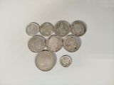 some coins are sitting on a white surface next to each other
