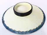 a white and blue plate with a black bowl on it