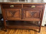 a wooden cabinet with a marble top on a wooden floor