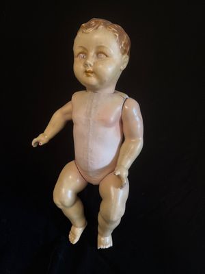 une vieille poupée en porcelaine posée sur une surface noire