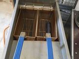 a deep fryer that has two blue tongs in it