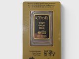 un lingot d'or dans son emballage, posé sur une surface blanche