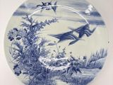 une assiette bleue et blanche ornée d'un motif représentant des oiseaux