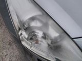 a close up of a car ' s headlight on the side of the road