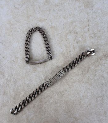 un bracelet en argent et un autre bracelet en argent posés sur une surface blanche