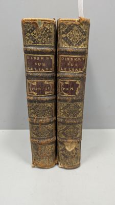 deux vieux livres posés l'un sur l'autre sur une table