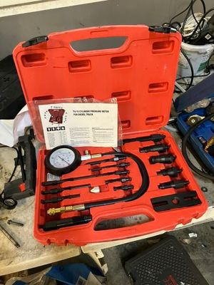 une mallette rouge contenant des outils, posée sur une table