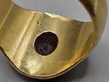 an image of a gold ring with a black stone in the middle