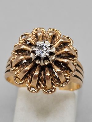 gros plan d'une bague en or avec un diamant au centre