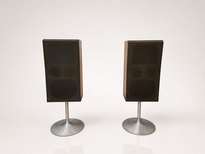 pair of speakers on metal stands against a white background
