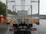 a truck with a cage on the back parked in a parking lot