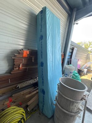 un matelas bleu posé sur un tas de bois